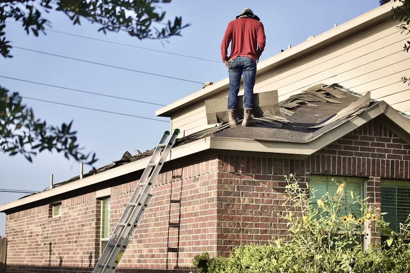 Professional roofer working on a residential roof in Bird Road Farmsites